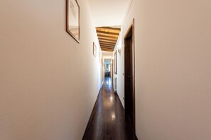 A hallway with wooden flooring, white walls, and framed pictures. - San Giovanni House by Mmega (Florence)