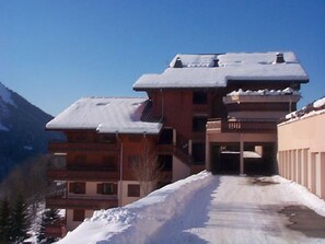 A multi-story building with a snow-covered roof and a clear sky.