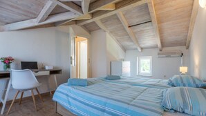 A bedroom with a bed, a desk, a chair, and a window.