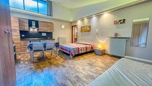 A compact room with a bed, a small table, and a kitchenette. - Tabor - STUDIO  sleeps 4 (Bardonecchia)