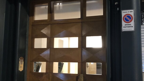 Eine Holztür mit Glasfeldern und einem Metallgriff.