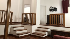 Eine Treppe mit hölzernen Geländern, die zu einer Zwischenebene führt.