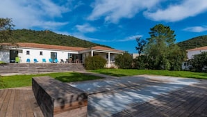 Une maison moderne dotée d’un patio, d’une piscine et située sur une colline, avec une vue imprenable.