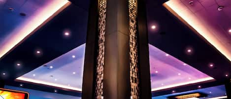 A casino interior with slot machines and a central pillar.