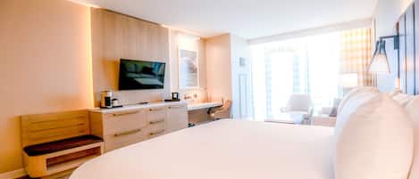 Una camera d'albergo moderna con un letto grande, una scrivania, una sedia e un televisore.