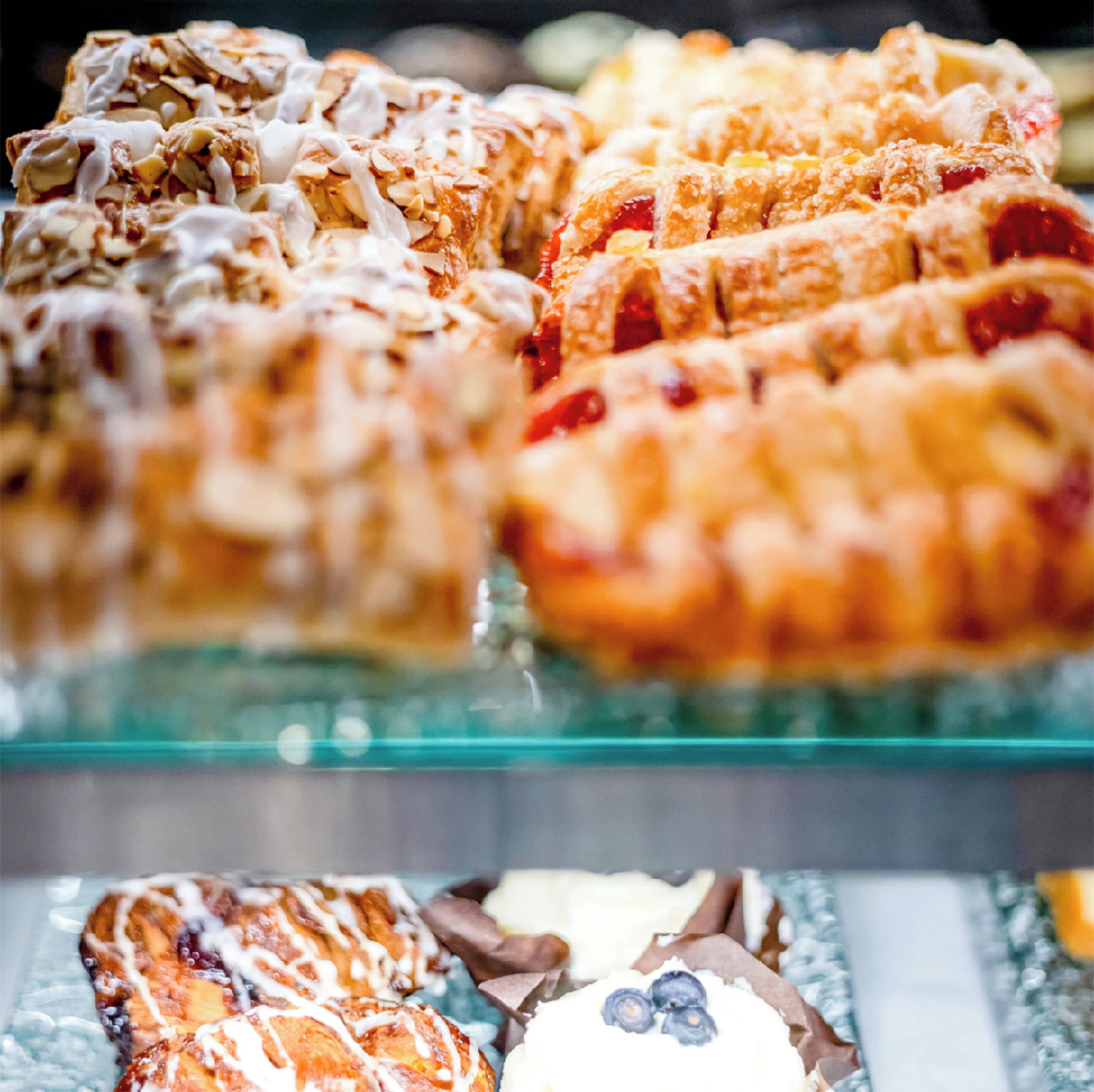 A variety of pastries displayed on a glass counter.