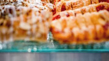 A variety of pastries displayed on a glass counter.