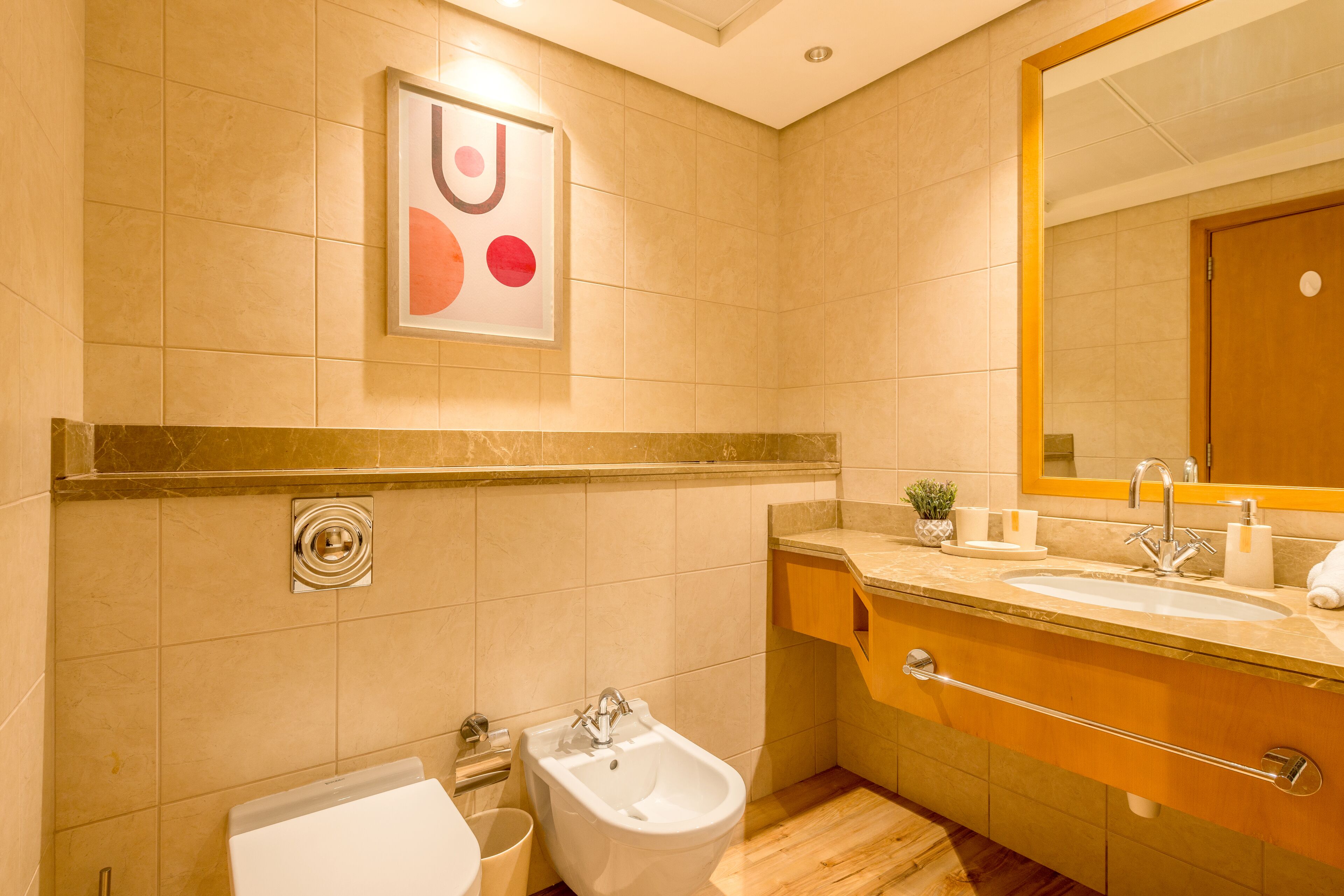 A modern bathroom with a bidet, sink, and mirror.