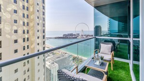 A balcony with a view of a Ferris wheel, a beach, and a cityscape. - Al Fattan - Sea View - Luxury JBR - Free Beach Resorts Access! (Dubai)