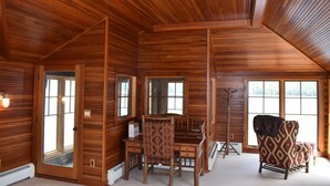 A log cabin interior with a dining table, chairs, and a fireplace. - Stunning Blue Mountain Lake - Waterfront Property! (Blue Mountain lake)