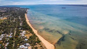 An aerial view of a coastal area with a sandy beach, residential buildings, and a large body of water. - SilverTide Retreat in Silverleaves (Silverleaves)