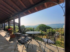An outdoor patio with a table and chairs, overlooking a scenic landscape.