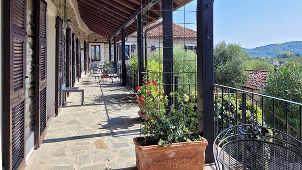 Un espace extérieur abrité, doté d’un sol en pierre, de rampes en métal et de plantes en pot.