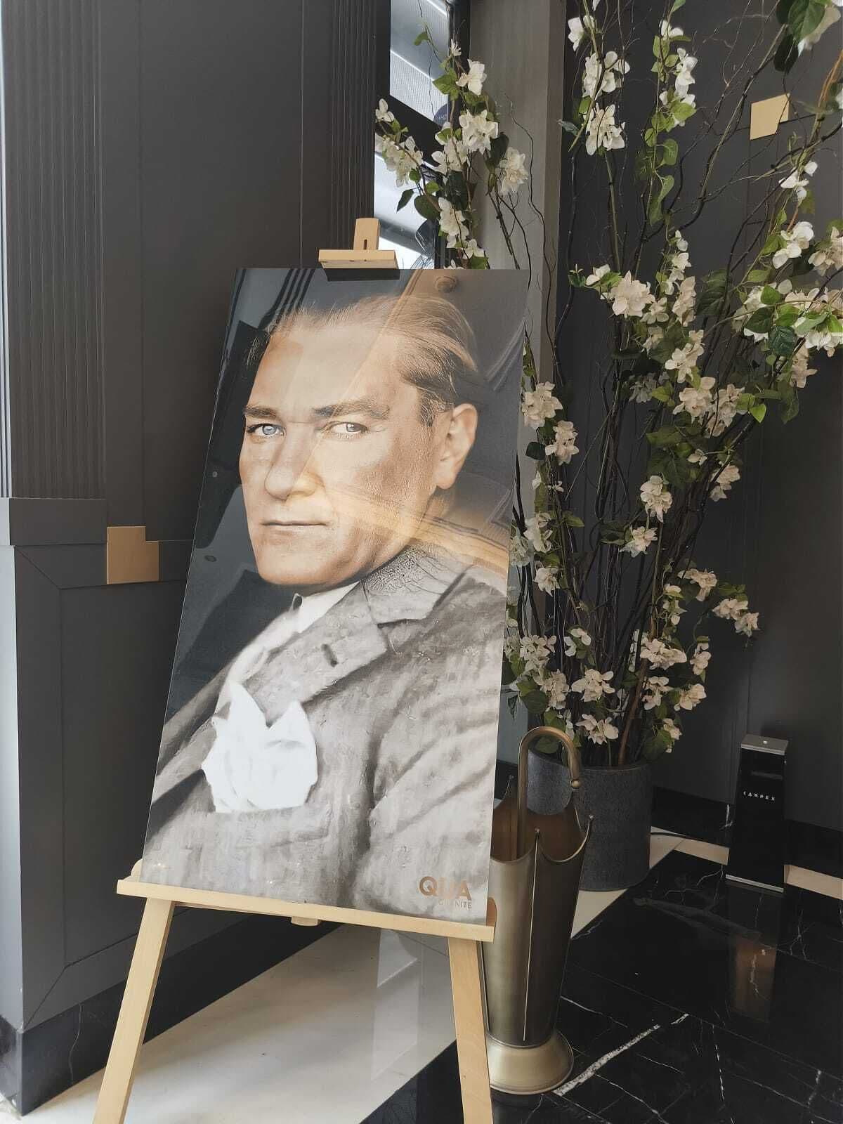 Un retrato pintado sobre caballete en una habitación moderna con paredes oscuras y suelo de mármol.