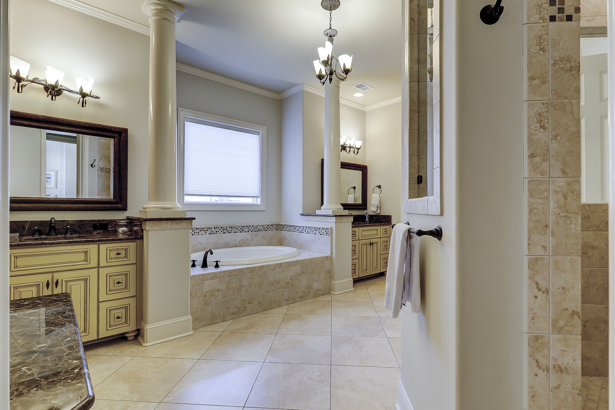 A spacious bathroom with a large bathtub, a double sink vanity, and a walk-in shower.