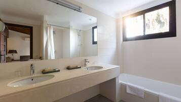 A modern bathroom with two sinks, a large mirror, a shower, and a bathtub.