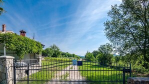 Une propriétéClose, entourée d’un mur en pierre et dotée d’un portail en métal.