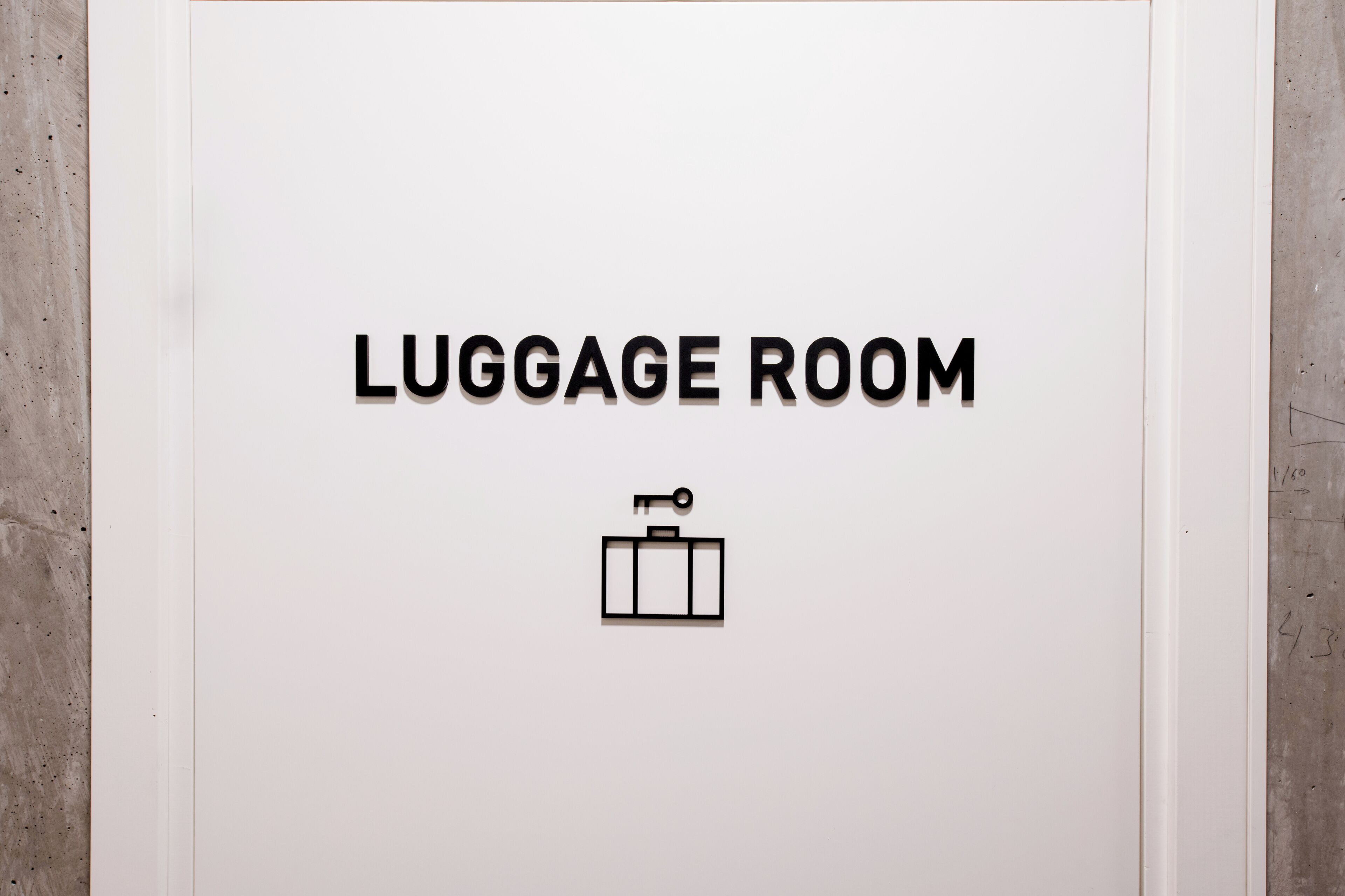 Segnaletica con il testo 'LUGGAGE ROOM' e un'icona di valigia.