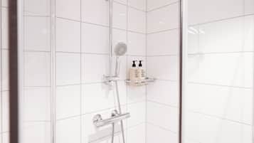 Un espace douche équipé d’un pommeau de douche à main, d’un pommeau de douche fixé au mur et d’un distributeur de savon placé sur une étagère.