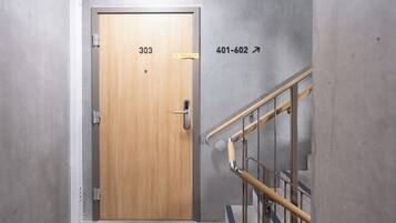 A wooden door with the number 303, a metal handrail, and a wall with the number 401-602.