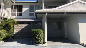 A two-story house with a covered driveway and a gated entrance labeled "Visitor Parking."