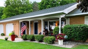 Une maison de plain-pied dotée d’un porche abrité, d’une façade en briques et d’une pelouse bien entretenue.