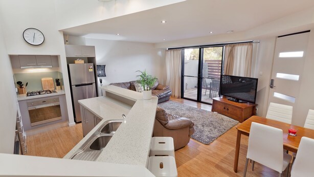 Un appartement moderne comprenant une cuisine, un coin repas et un salon.