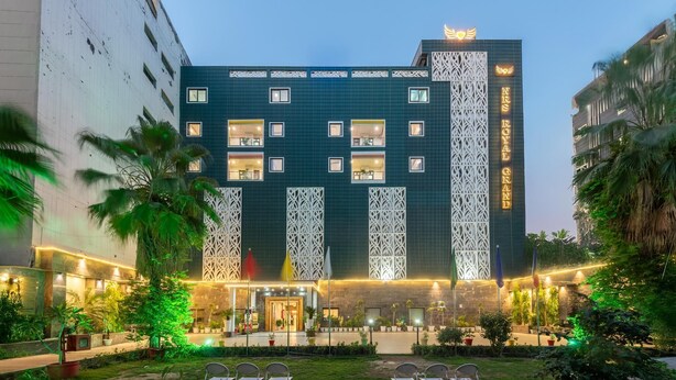 Een hotel met meerdere verdiepingen, een moderne gevel, balkons en een goed verlichte ingang.