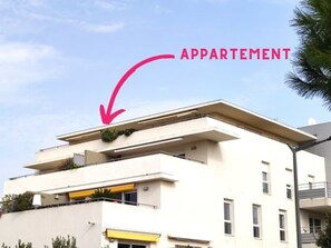 A modern apartment building with a flat roof and balconies.