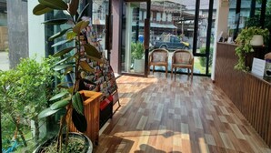 Een modern interieur met een houten vloer, grote ramen en een zithoek met twee stoelen.