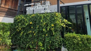 Een hotelschild met een modern gebouw op de achtergrond.