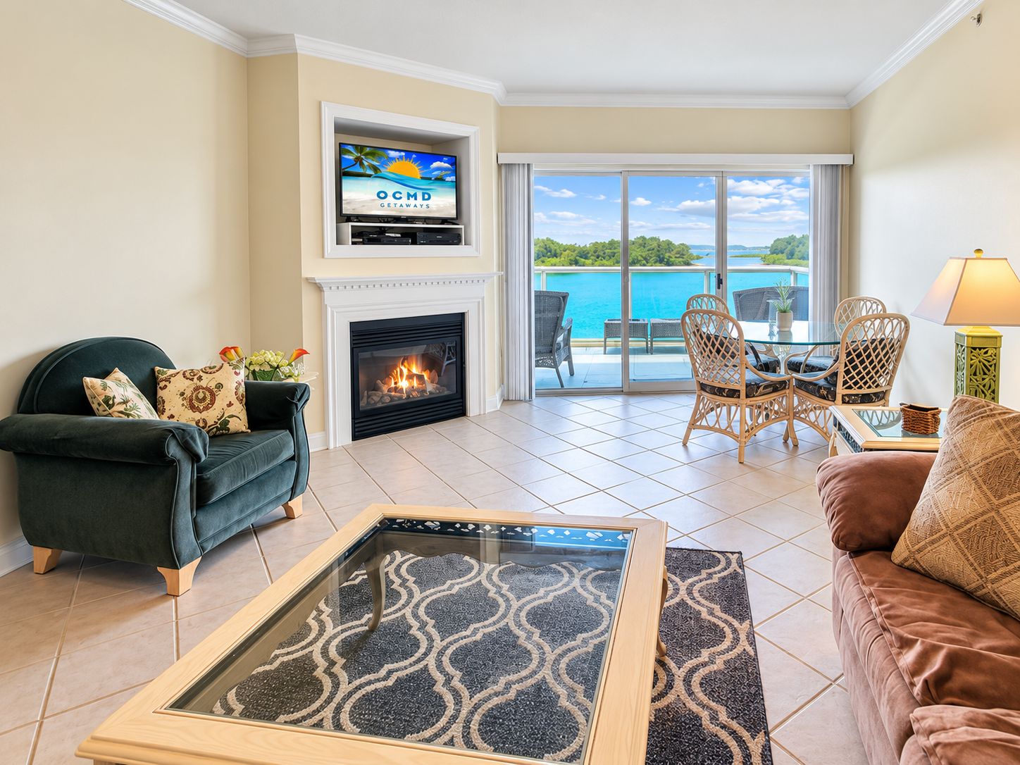 A living room with a fireplace, a television mounted above it, and a view of a pool.