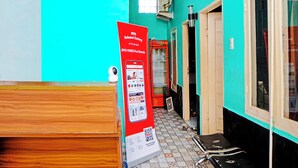 A hallway with a red sign, a security camera, and a tiled floor.