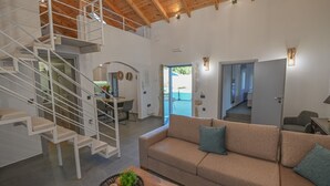 A modern interior with a staircase, a sofa, and a dining area.