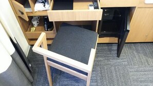 Habitación compacta con escritorio plegable, un pequeño rincón de descanso, cafetera y microondas.