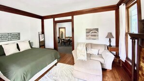 Une chambre à coucher avec un lit, un canapé, une lampe et une cheminée.
