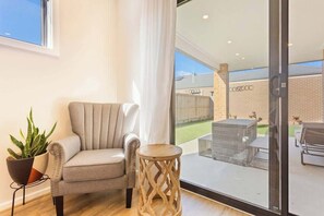 A room with a sofa, a small wooden side table, and a potted plant.