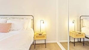 A bedroom with a bed, two bedside tables, a mirror, and a nightstand. - Modern Beach House w/ BBQ & Family-Friendly Charm (Cowes)