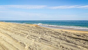 A beach with a clear sky and ocean waves. - La Carolina del Mar - KDH MP 5.5, 250 Yds to Beach, Ocean View, Hot Tub, Flex Stays (Kill Devil Hills)