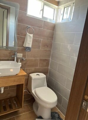 Een douche, handdoeken, zeep, toiletpapier