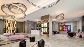 A spacious lobby with modern furniture, a reception desk, and unique circular ceiling lights. - Suite Ocean View w/JACUZZI, POOL, GYM and MORE (Hollywood)