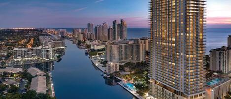 A high-rise hotel with multiple floors, a swimming pool, and a marina.
