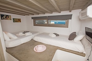A room with two beds, a window, and a ceiling fan.