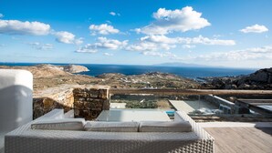 Terraço no telhado com vista para o mar e paisagem rochosa.