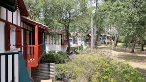 A traditional building with a balcony, surrounded by trees and greenery. - Villa 'Christine' with Shared Pool, Shared Garden, and Balcony (Moliets-et-Maa)