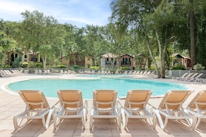 A swimming pool with lounge chairs, surrounded by trees and buildings. - Villa 'Christine' with Shared Pool, Shared Garden, and Balcony (Moliets-et-Maa)