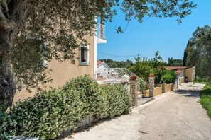 A residential building with a staircase, a balcony, and a paved driveway. - Apartment 'Marketos  Maisonette  4pax' with Mountain View, Wi-Fi and Air Conditioning (Kefalonia)
