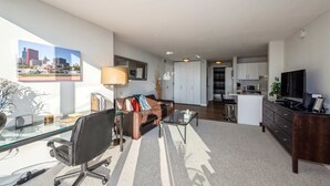 Ein modernes Wohnzimmer mit einem Glastisch, einer Ledersofa und einem Stadtbild.