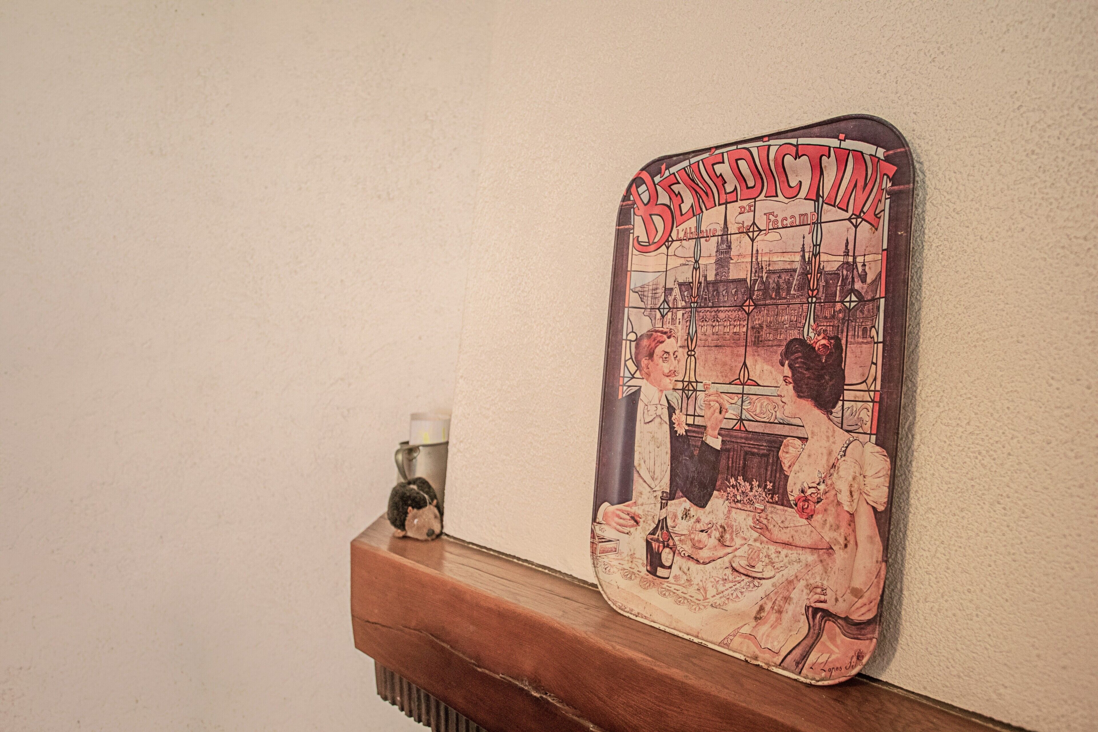 A vintage-style wall hanging with the word 'BENEFITINE' and a scene of two people.