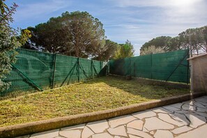 Un'area esterna recintata con un patio in pietra.